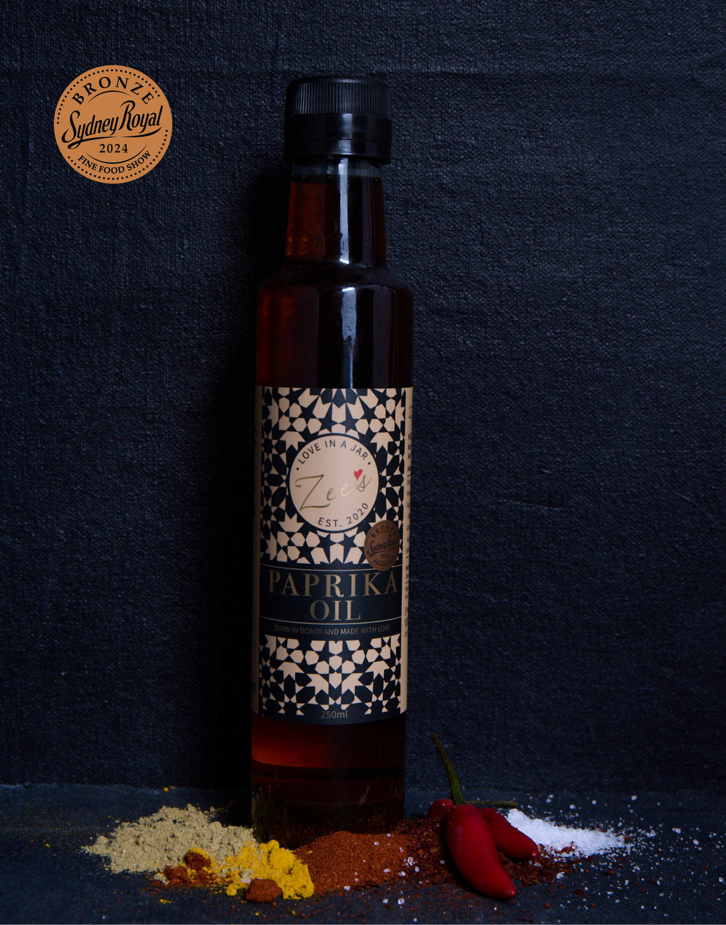 Bottle of paprika oil with spices on a dark background